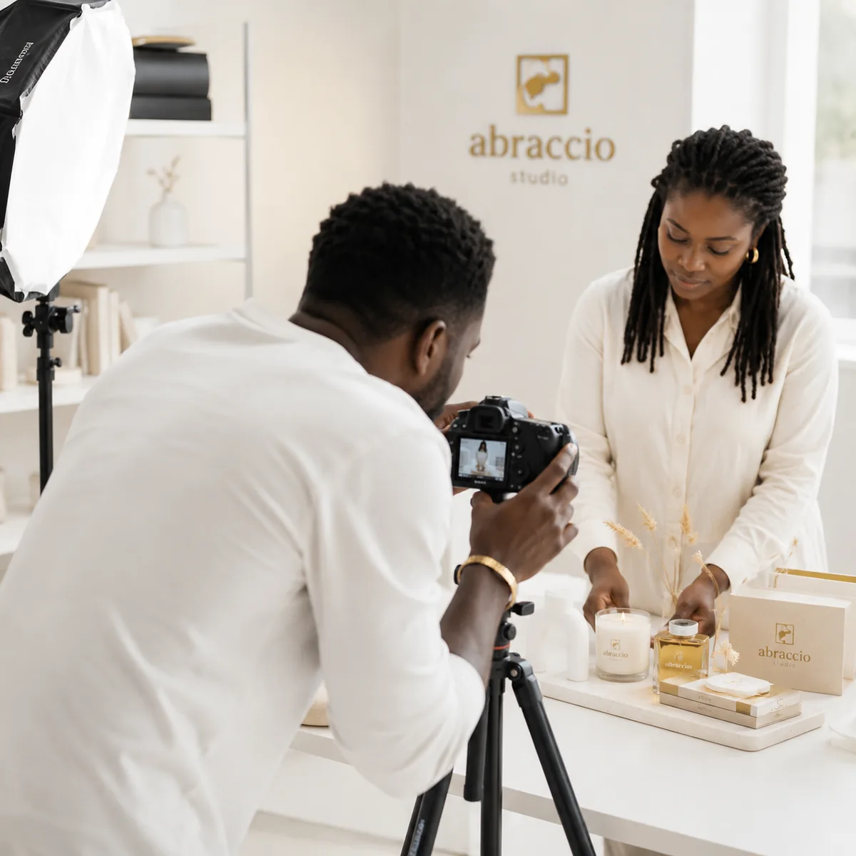 Fotógrafo a captar um produto em estúdio, com o softbox montado e a equipa a compor a mesa.